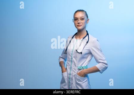 Giovane medico donna che indossa occhiali di sicurezza e stetoscopio Foto Stock