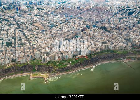 Vista aerea del distretto di Miraflores a Lima, Perù, con parchi verdi, edifici moderni, scogliere ripide, e spiagge panoramiche lungo il Pacifico Foto Stock