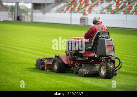 Erba falciante allo stadio di calcio Foto Stock