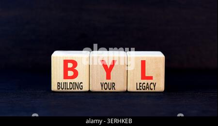 BYL sta costruendo il tuo simbolo legacy. Parole concettuali BYL costruisce la tua eredità su splendidi blocchi di legno. Splendido sfondo nero. Business BYL Building Foto Stock