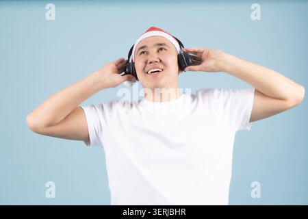 Giovane sorridente mentre ascolta la musica con le cuffie Foto Stock