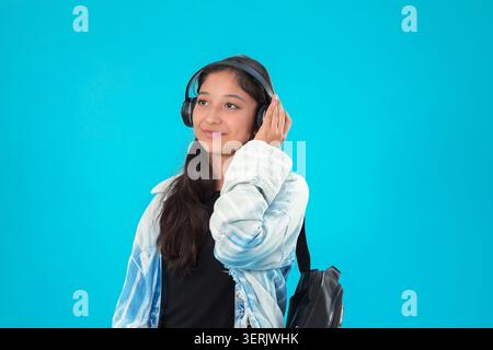Donna che indossa le cuffie sorridenti in un ritratto in studio Foto Stock
