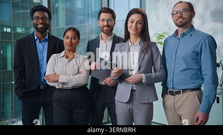 Ritratto multietnico caucasico africano indiano arabo business team cinque uomini donne uomini d'affari colleghi sorridono in posa sicuro sul posto di lavoro Foto Stock