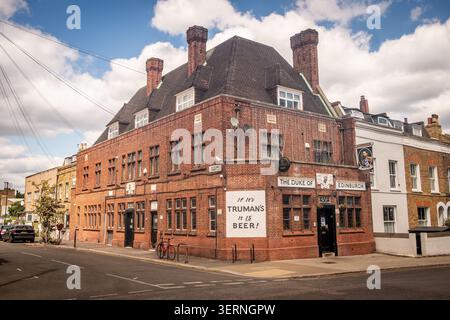 LONDRA - 12 MAGGIO 2026: The Duke of Edinburgh - tradizionale pub Truman's in mattoni rossi in una tranquilla Brixton Street. Foto Stock