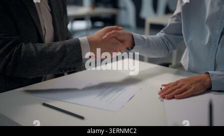 Due colleghi d'affari caucasici irriconoscibili firmano mano mano mano stretta di mano uomo donna che stringe le mani assicurazione documento bancario sconosciuto Foto Stock