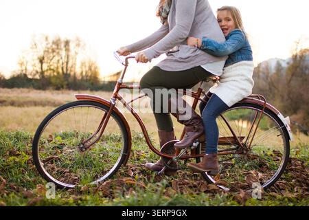 Donna che fa un giro in bicicletta d'epoca alla figlia Foto Stock