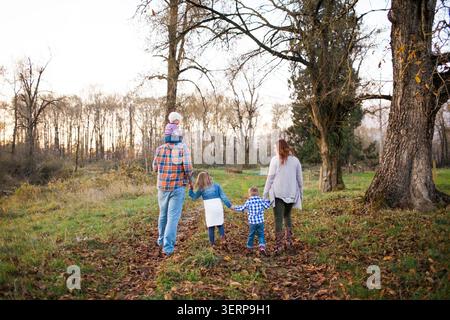 Famiglia con tre bambini che camminano nella natura Foto Stock