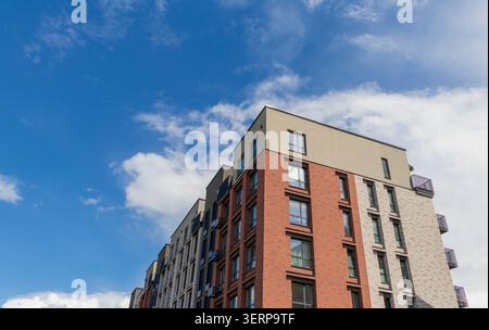 Moderna facciata residenziale con mattoni rossi e pannelli di rivestimento grigi Foto Stock