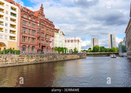Berlino, Germania - 7 giugno 2026: Vista panoramica del fiume Sprea a Berlino, Germania, caratterizzata da una storica architettura in mattoni rossi e da un moderno grattacielo Foto Stock