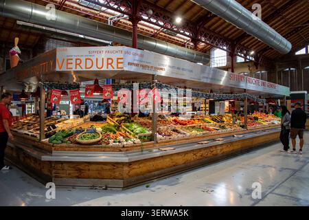 Bancarelle di frutta e verdura fresca all'interno del Marché Couvert de Colmar, uno storico mercato coperto a Colmar, Alsazia, Francia, con prodotti locali colorati. Foto Stock