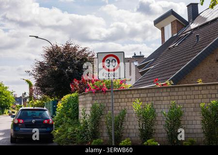 Kaarst, Germania, 10.06.2026 - segnale di limite di velocità 30 zona su una tranquilla strada residenziale europea, segnale di traffico tedesco per bassa velocità in un quartiere periferico Foto Stock