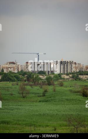 Una vista di un cantiere con diversi grattacieli in fase di sviluppo, con una gru prominente sullo sfondo. Il primo piano è dom Foto Stock