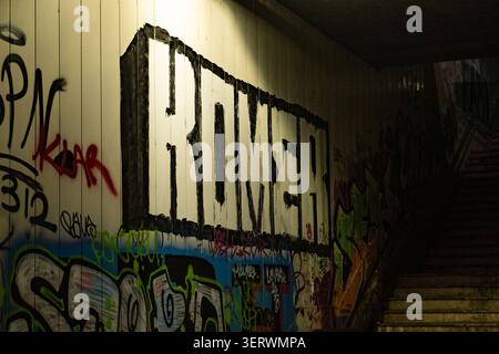 Si tratta di una scena urbana grintosa caratterizzata da un muro ricoperto da vivaci graffiti. Foto Stock