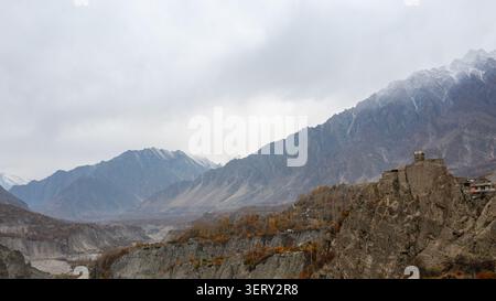 Vista aerea del forte di Altit arroccato su una scogliera rocciosa che si affaccia sulla valle di Hunza con fogliame autunnale e montagne innevate ad Altit, Gilgit, Pakist Foto Stock
