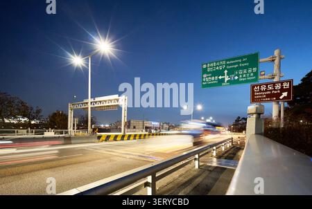 Vista notturna del ponte Yanghwa a Seoul con sentieri a semaforo. Il cielo blu profondo offre uno spazio di copia ideale per i moderni progetti urbani e di trasporto. Foto Stock