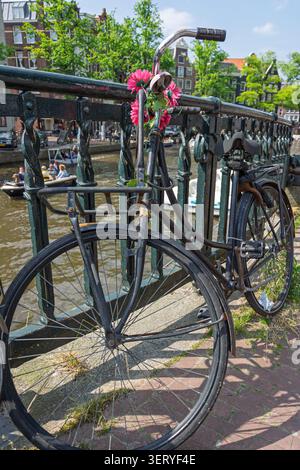 Amsterdam, Paesi Bassi. 21 giugno 2014, bicicletta decorata con fiori sul ponte dei canali di Amsterdam Foto Stock