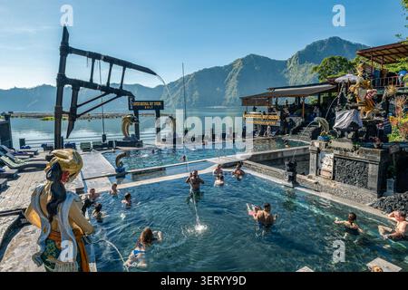 Bali, Indonesia - 5 giugno 2026: I turisti nuotano e si rilassano nelle piscine termali della sorgente termale naturale di Batur. Situato nel villaggio di Toya Bungkah, in Foto Stock