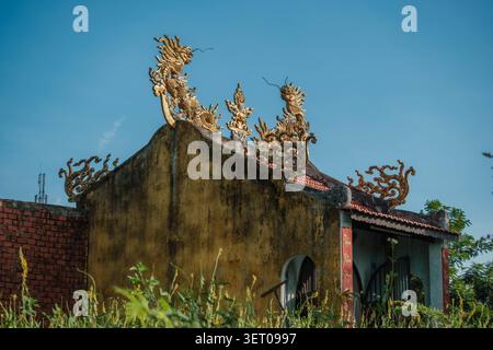 Tradizionale edificio di santuario asiatico con statue di draghi dorati sul tetto Foto Stock