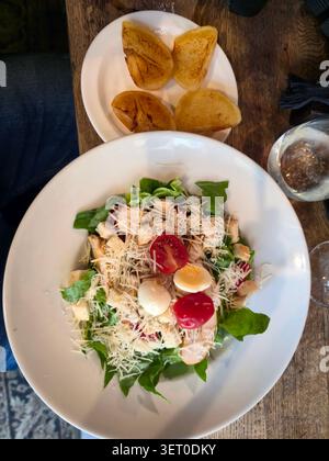 Insalata Caesar fresca con uova sode, pomodorini e pane tostato su tavolo di legno Foto Stock