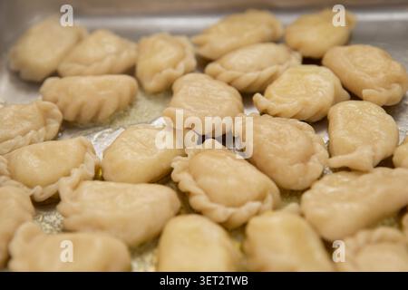 Gnocchi varenyky ucraini tradizionali con burro su un vassoio di metallo, vista dall'alto in primo piano Foto Stock