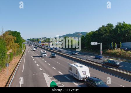 Traffico su un'autostrada francese con un'auto che traina una roulotte in vacanza primaverile. Foto Stock