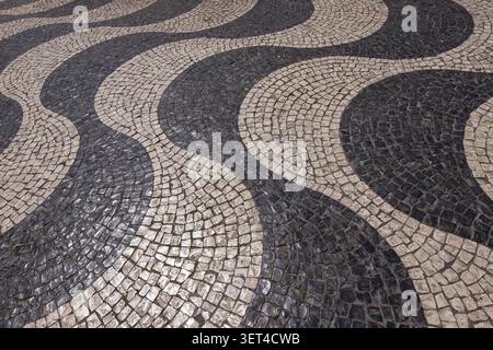 Motivo ondulato di pietre di pavimentazione bianche e nere a terra, pavimentazione stradale, Lisbona, Portogallo Foto Stock