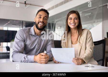 Due amichevoli colleghi si mettono in posa insieme in un ufficio moderno Foto Stock