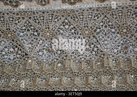 Primo piano di delicati motivi a mosaico geometrici e floreali sullo specchio del soffitto del palazzo a Jaipur. Foto Stock
