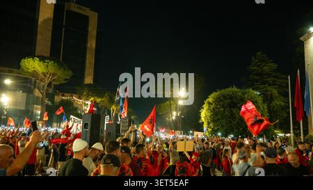 Tirana, Albania – 20 giugno 2026: I manifestanti tengono i telefoni cellulari e gli striscioni politici durante una protesta notturna affollata. Foto Stock