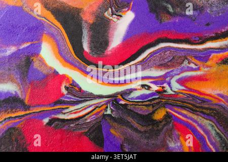 Colori vivaci e vorticosi di viola, arancione e nero per creare una texture astratta in schiuma Foto Stock