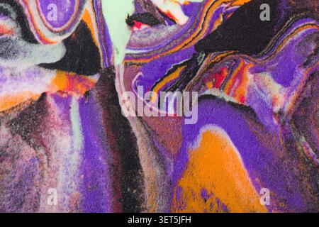 Colori vivaci e vorticosi di viola, arancione e nero per creare una texture astratta in schiuma Foto Stock