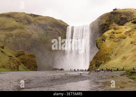 Maestoso cascata di Skogafoss che si riversa su scogliere muschiose nel sud dell'Islanda. Foto Stock