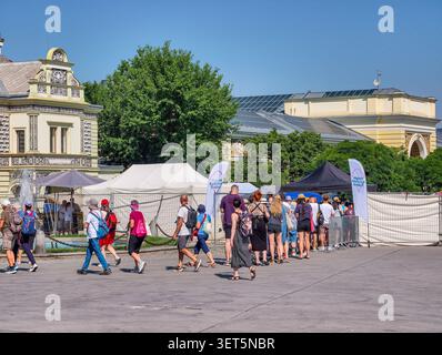 Praga, Repubblica Ceca - 21 giugno 2026: I visitatori aspettano in fila all'ingresso della mostra di Praga in un giorno di sole nel fine settimana. Famiglie, coppie. Foto Stock