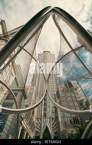 Charlotte, North Carolina, Stati Uniti d'America - 30 maggio 2026: Architettura Gothis e cielo spettacolare visto attraverso la scultura pubblica Foto Stock