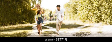 Felice ragazza acceso dai suoi genitori, avente picnic in campagna Foto Stock
