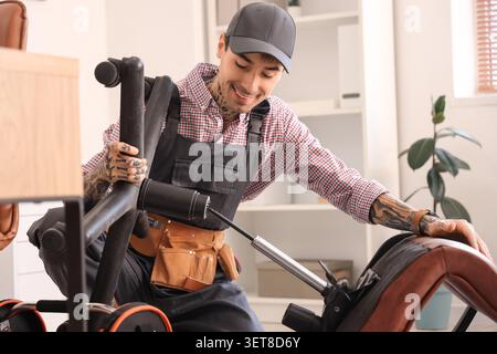 Lavoratore maschio che assembla la sedia in ufficio Foto Stock