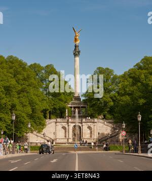 Vista del monumento dorato di Friedensengel, o Angelo della Pace, a Monaco, con la sua alta colonna, terrazza panoramica, fontana e parco circostante Foto Stock