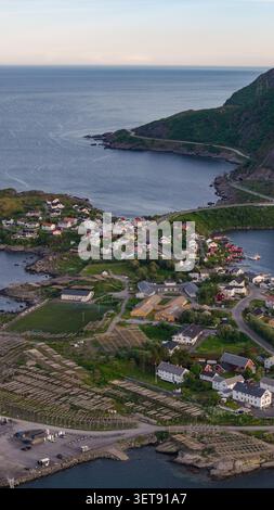 Panorama aereo di un pittoresco villaggio costiero norvegese nelle isole Lofoten con case colorate, montagne verdi, fiordi e suggestivi Foto Stock
