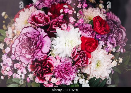 Bouquet di fiori colorato con rose e garofani. Sfondo floreale per feste compleanni regali e occasioni speciali. Foto Stock