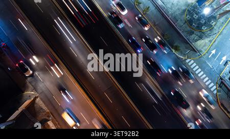 Vista aerea di un'autostrada trafficata di notte con sentieri leggeri di veicoli in movimento, catturati da un'angolazione elevata nella Repubblica Dominicana. Foto Stock