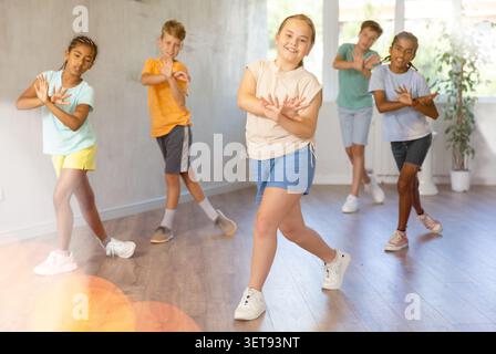 Sorridente tra una ragazza che impara danze dinamiche moderne in una lezione di coreografia Foto Stock