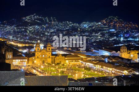 Vista notturna di Cusco, Perù, con ritrovo pubblico nel centro storico illuminato, Plaza de Armas, di fronte alla cattedrale e alla chiesa di Cusco Foto Stock
