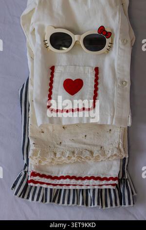 Piatto alla moda per bambini con occhiali da sole e abito estivo bianco Foto Stock