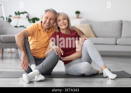 Felice anziano coppia caucasica che fa Yoga insieme a casa, sorridente, concetto di benessere Foto Stock