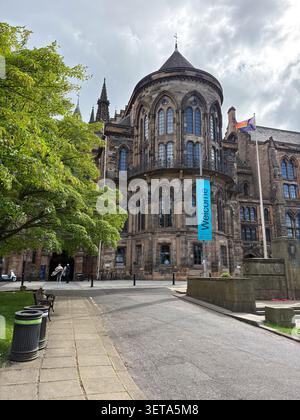 Architettura neogotica dell'Università di Glasgow, caratterizzata da una torre in pietra, finestre ad arco e un'importante insegna di benvenuto. Glasgow, Scozia. Foto Stock