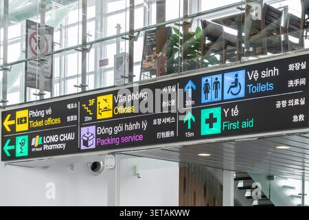 L'immagine mostra un cartello di ricerca della via aeroportuale multidirezionale con testo in più lingue, tra cui vietnamita, inglese, coreano e cinese. Foto Stock
