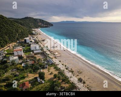 Uno scatto aereo cattura l'ampia spiaggia di Dhermi in Albania, mostrando l'impressionante contrasto tra il blu profondo e le vibranti acque turchesi di Foto Stock