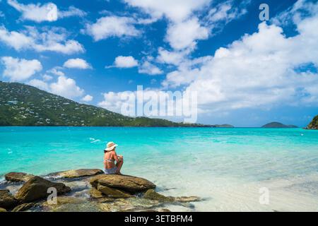 Donna con cappello da sole che gode della vista tropicale Foto Stock