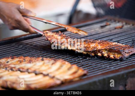 Primo piano di lastre di costolette al barbecue cucinate su un grande grill all'aperto Foto Stock