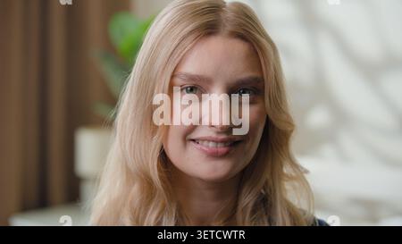 Ritratto felice faccia caucasica femminile sorridente con sano dentale toothy sorriso a casa. Primo piano una donna europea attraente che guarda la macchina fotografica Foto Stock